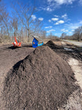 Load image into Gallery viewer, A large pile of finished compost with a tractor and compost screener in the background