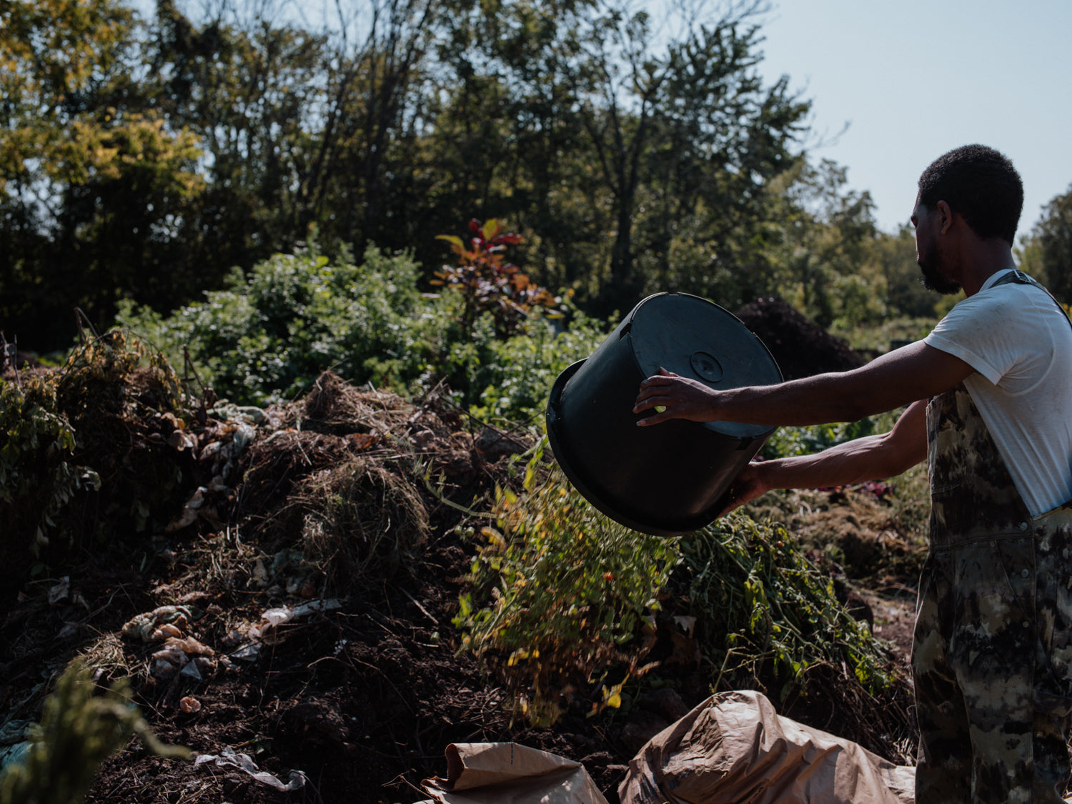 jøn kent adding compostable material to a compost pile