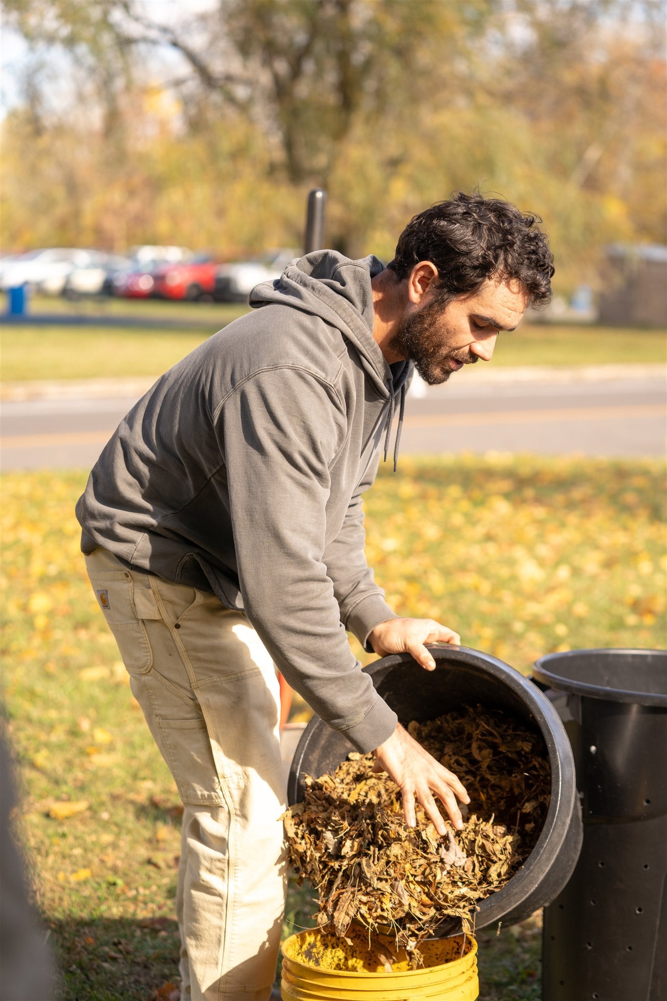 Parker Jean holding a bucket of leaves to be composted