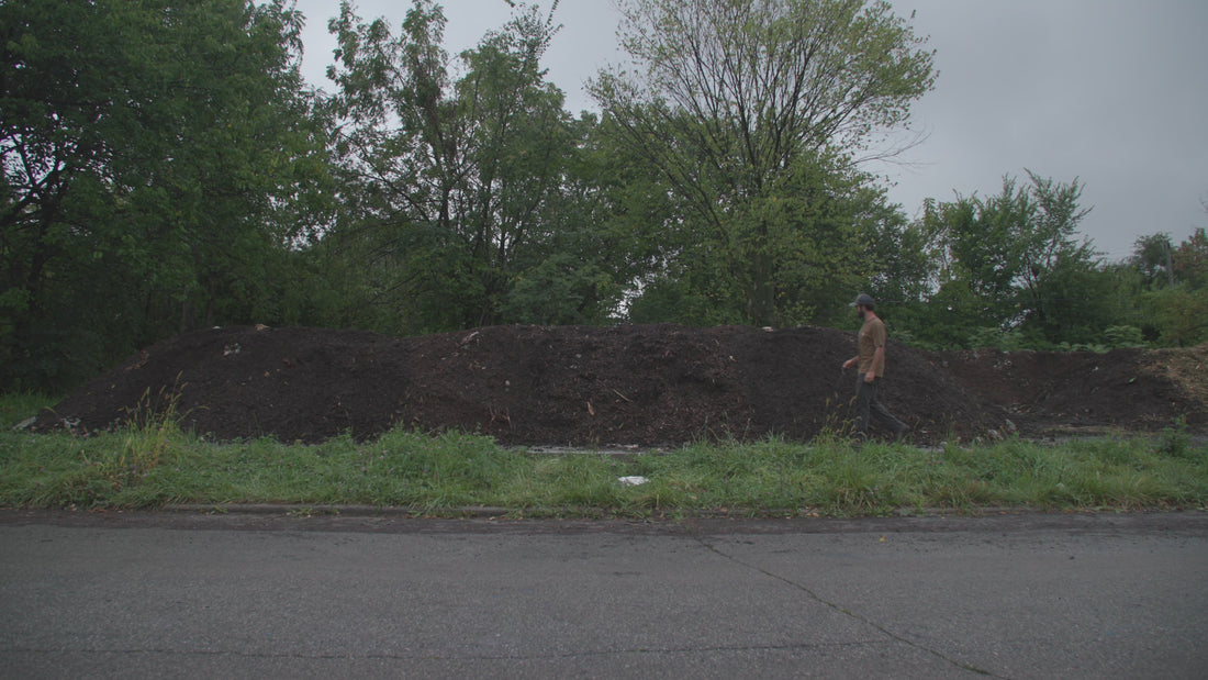 Parker Jean walking by a large compost pile at Sanctuary Farms